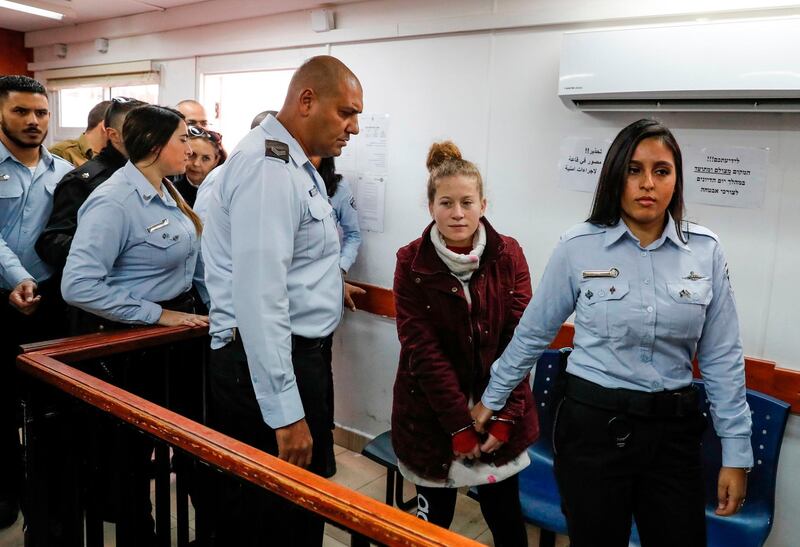 Palestinian Ahed Tamimi (2nd-R), 17, a well-known campaigner against Israel's occupation, appears at a military court at the Israeli-run Ofer prison in the West Bank village of Betunia on December 20, 2017. 
Israel's army arrested Tamimi on December 19, 2017, after a video went viral of her slapping Israeli soldiers in the occupied West Bank as they remained impassive. / AFP PHOTO / AHMAD GHARABLI