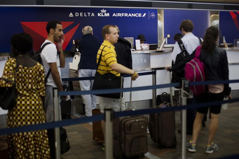 Travellers wait to check in for flights at the Delta Air Lines counter of LaGuardia Airport in New York. Victor Blue / Bloomberg