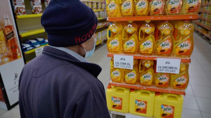 A shopper checks the price of cooking oil at a supremarket in Beirut, Lebanon. Mahmoud Rida