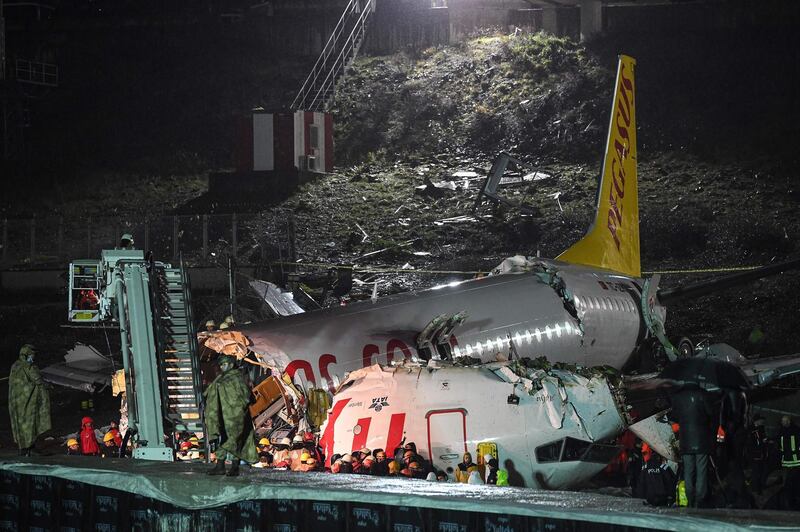 Turkish soldiers stand guard as rescuers work to extract passengers from the crash of a Pegasus Airlines Boeing 737 airplane, after it skidded off the runway upon landing at Sabiha Gokcen airport in Istanbul on February 5, 2020.  The plane carrying 171 passengers from the Aegean port city of Izmir split into three after landing in rough weather. Officials said no-one had lost their lives in the accident, but dozens of people were injured. / AFP / Ozan KOSE
