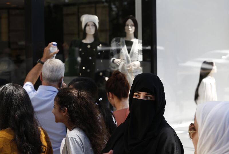 CORRECTING CAPTION BYLINE TO LEFTERIS PITARAKIS - Tourists queue outside a luxury goods store at an upscale neighborhood of Istanbul, Tuesday, Aug. 14, 2018, to snap up bargains after Turkish lira sinks to a record low. The decline of the Turkish lira offers shoppers the advantage of purchasing luxury items at cheaper prices. The Turkish lira has nosedived in value in the past week over concerns about Turkey's President Recep Tayyip Erdogan's economic policies and after the United States slapped sanctions on Turkey angered by the continued detention of an American pastor. (AP Photo/Lefteris Pitarakis)
