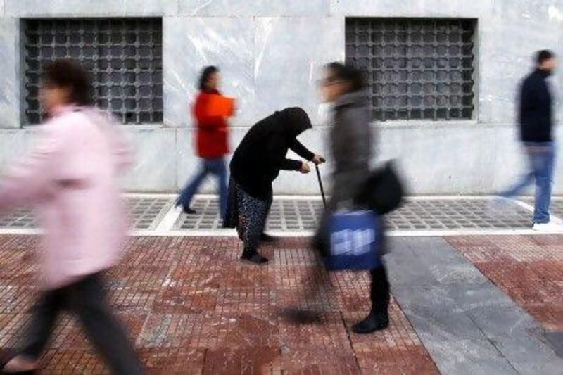 A woman begs in Athens in February when austerity measures kicked in. Despite multi-billion euro rescue packages to prop up Greece, the fate of the euro, the single currency adopted by 17 countries hangs in the balance.