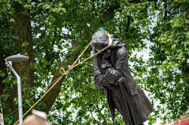 The statue of Edward Colston falls down as protesters pull it down, following the death of George Floyd who died in police custody in Minneapolis, in Bristol, Britain, June 7. Picture taken June 7. Keir Gravil / via REUTERS 