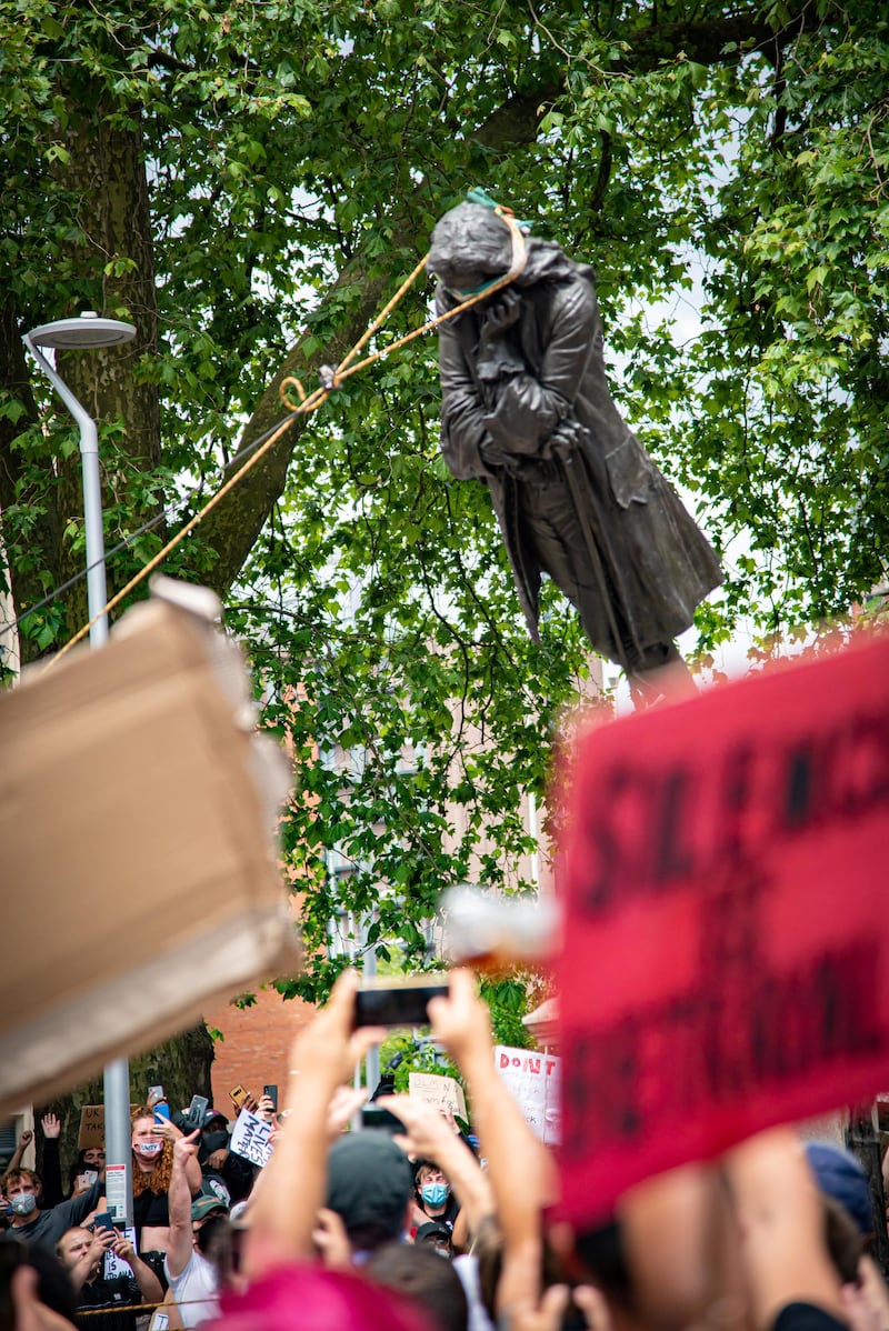 The statue of Edward Colston falls down as protesters pull it down, following the death of George Floyd who died in police custody in Minneapolis, in Bristol, Britain, June 7, 2020. Picture taken June 7, 2020. Keir Gravil/via REUTERS THIS IMAGE HAS BEEN SUPPLIED BY A THIRD PARTY. MANDATORY CREDIT.