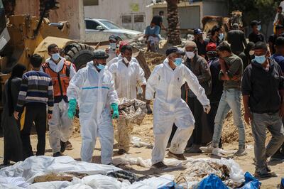 Palestinian health workers recover bodies from a mass grave at Nasser Hospital compound in Khan Younis. Bloomberg
