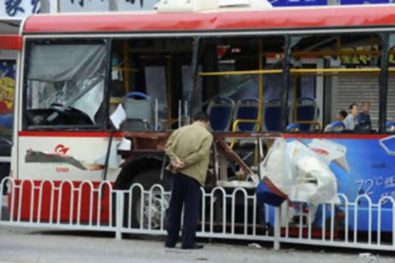 A man inspects the damage to one of the buses blown up in Kunming. The blasts came amid a security clampdown ahead of next month's Beijing Olympics.