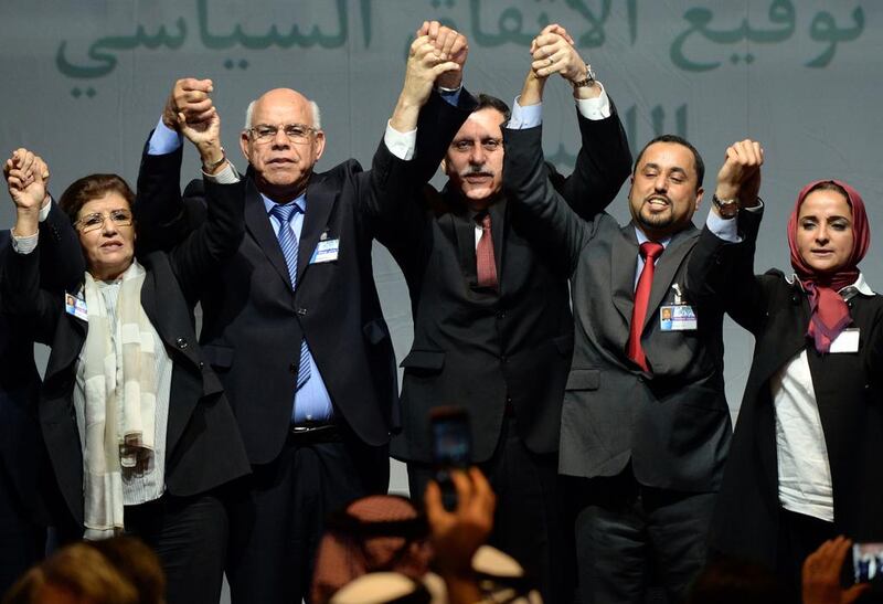 The head of Libya’s new national government, Fayez Al Sarraj, centre, celebrates with the deputy head of Libya’s House of Representatives, Mohamed Ali Shoeb, left, and the deputy president of General National Congress, Saleh Al Makhzoum, right, both of whom have now been disowned by their respective legislatures, after signing a deal on a unity government on December 17, 2015, in Skhirat, Morocco. Fadel Senna / AFP