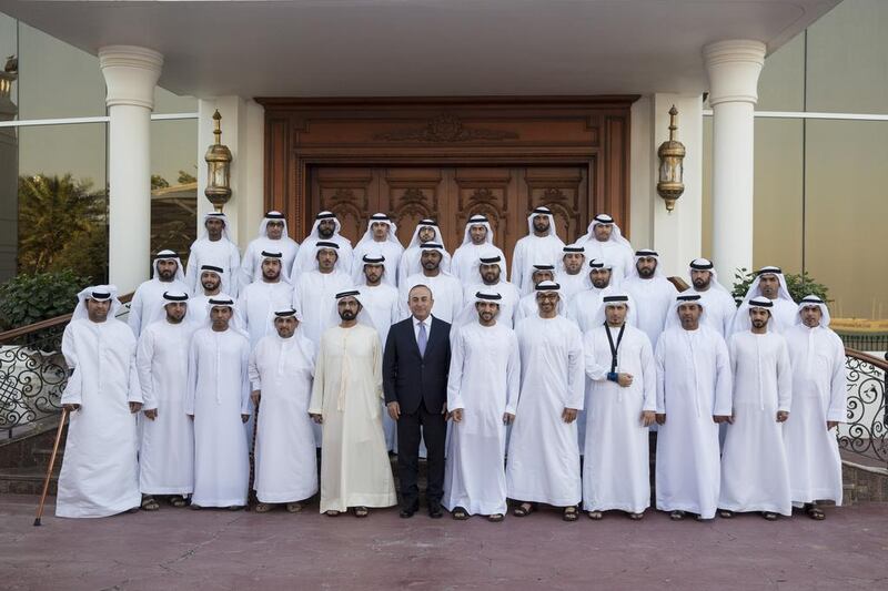 Sheikh Mohammed bin Rashid, Vice President and Ruler of Dubai, Sheikh Mohammed bin Zayed, Crown Prince of Abu Dhabi and Deputy Supreme Commander of the Armed Forces, Sheikh Hamdan bin Mohammed, Crown Prince of Dubai, and Mevlut Cavusoglu, Minister of Foreign Affairs of Turkey, stand for a photograph with Armed Forces servicemen injured while serving the armed forces in Yemen. Seen during a Sea Palace barza. Ryan Carter / Crown Prince Court - Abu Dhabi