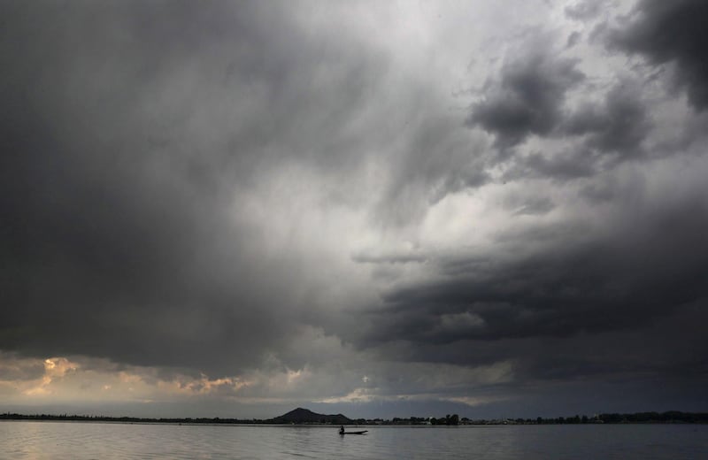 A man rows a boat on Dal Lake in Srinagar, the summer capital of Indian-administered Kashmir. Rain lashed the city and other parts of Kashmir Valley after a day of sunshine. EPA