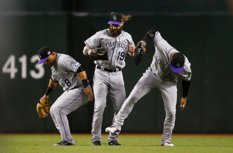Colorado Rockies' Gerardo Parra, Charlie Blackmon and Carlos Gonzalez celebrate after the final out of a baseball game against the Arizona Diamondbacks in Phoenix. Ross D. Franklin / AP Photo