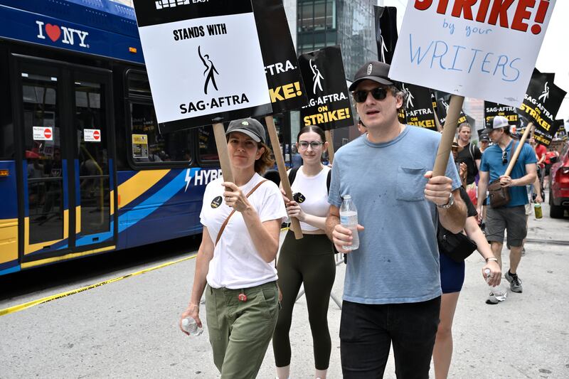 Tina Fey, left, and writer/producer Eric Gurian join protests in New York. AP