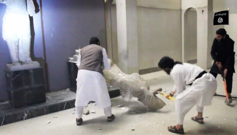 Militants take sledgehammers to an ancient artifact in the Ninevah Museum in Mosul. AP Photo via militant social media account