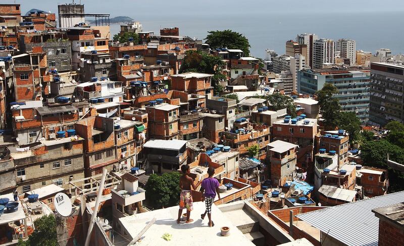 RIO DE JANEIRO, BRAZIL - FEBRUARY 21:  Boys gather while flying kites in the Cantagalo shantytown community next to neighboring Pavao-Pavaozinho on February 21, 2014 in Rio de Janeiro, Brazil. The pacified favelas stand above Copacabana and Ipanema beaches. Ahead of the World Cup, some of Rio's pacified favelas have seen an increase in violence, including a number of shootings in Cantagalo and Pavao-Pavaozinho. Around 10,000 people live in the Cantagalo and Pavao-Pavaozinho communities with a total of 1.7 million Rio residents residing in shantytowns, many of which are controlled by drug traffickers.  (Photo by Mario Tama/Getty Images)