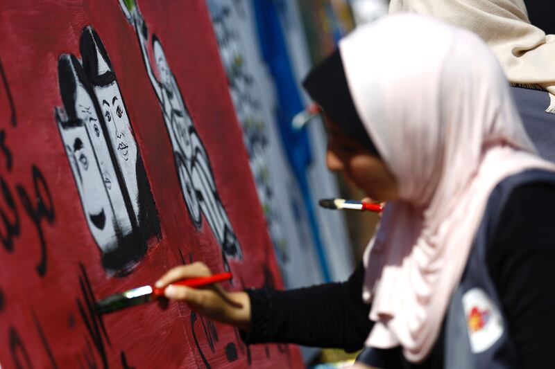 A Palestinian art student paints as she takes part in a festival marking World Mental Health Day in Gaza City. AFP