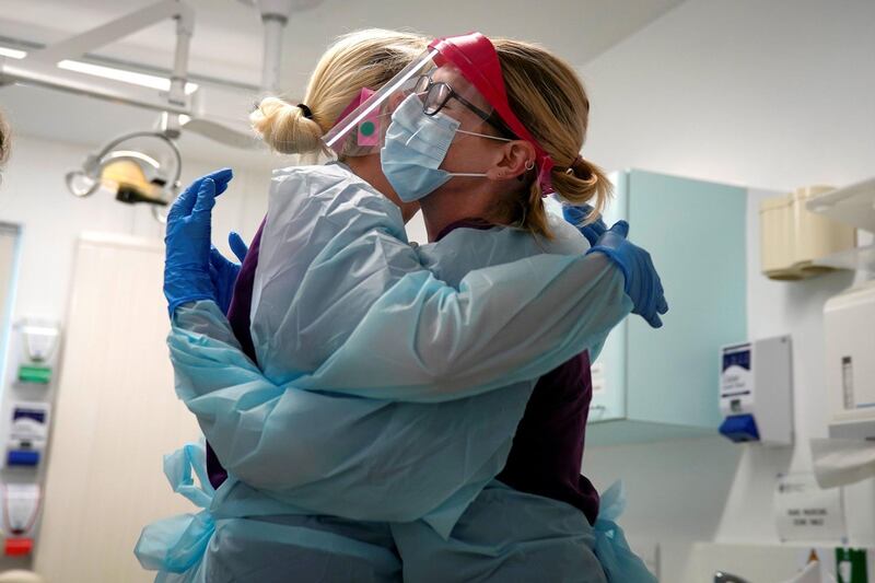 WREXHAM, WALES - MAY 14: Dental nurses embrace before treating a possible Covid-19 positive dental patient at the Dental Unit at Coed Celyn Hospital. It is the only time the nurses can embrace and have a team hug after fully dressing in their full personal protection equipment . The unit will be receiving funding for a blood coagulation monitor and hardware to enable remote meetings from local NHS charity Awyr Las (Blue Sky) on May 14, 2020 in Wrexham, Wales. As the National Health Service grapples with the Covid-19 pandemic, members of the British public have raised tens of millions of pounds for charities that support NHS institutions and their workers. In Wales, initiatives by the local NHS charity Awyr Las (Blue Sky) show how that fundraising translates to material assistance, going over and above what core NHS funds support. Awyr Las have funded items ranging from appliances and refreshments for staff break rooms to medical equipment like blood pressure monitors and catheterisation models. Awyr Las, one of over 200 NHS charities across the country, is part of NHS Charities Together, the national organisation of charities that was the beneficiary of Captain Tom Moore's historic fundraising campaign.  (Photo by Christopher Furlong/Getty Images)