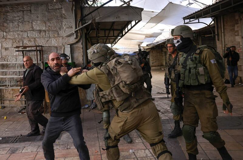 Israeli security forces hold back a Palestinian man amid altercations between Jewish settlers on their way to visit the tomb of Othniel ben Kenaz in the occupied West Bank city of Hebron, on November 19, 2022. AFP