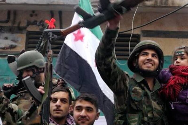 Syrian soldiers, who have defected to join the Free Syrian Army, hold up their rifles and wave Syrian independence flags, during a protest against Syria's President Bashar al-Assad in Khalidieh, near Homs January 26, 2012. Picture taken January 26, 2012. REUTERS/ Stringer    (SYRIA - Tags: POLITICS CIVIL UNREST MILITARY) *** Local Caption ***  SYR03_SYRIA-_0127_11.JPG