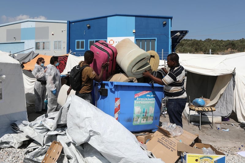 Refugees and migrants who were sheltered near the destroyed Moria camp, carry their belongings as they prepare to move to a new temporary camp, on the island of Lesbos, Greece.  Reuters