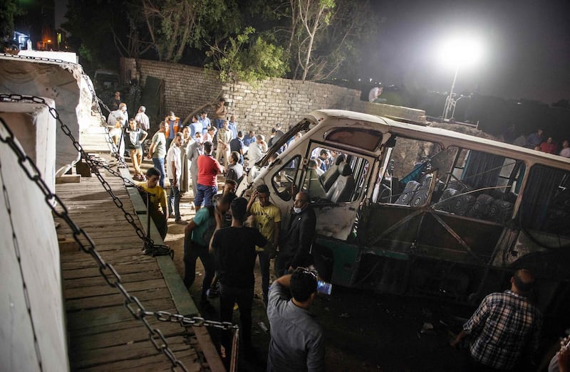 People surround one mini-bus after it collided with a cargo train. AFP