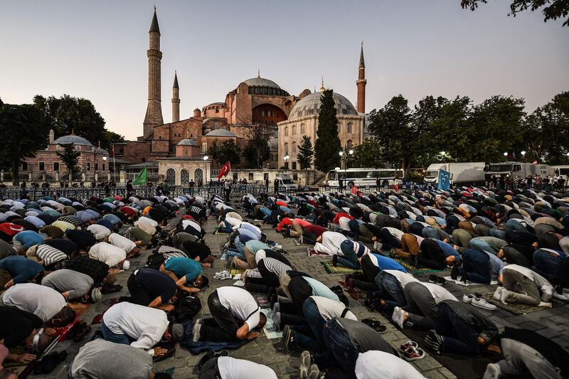People, some wearing face masks, pray outside the Hagia Sophia museum in Istanbul as they gather to celebrate after a top Turkish court revoked the sixth-century Hagia Sophia's status as a museum, clearing the way for it to be turned back into a mosque. AFP