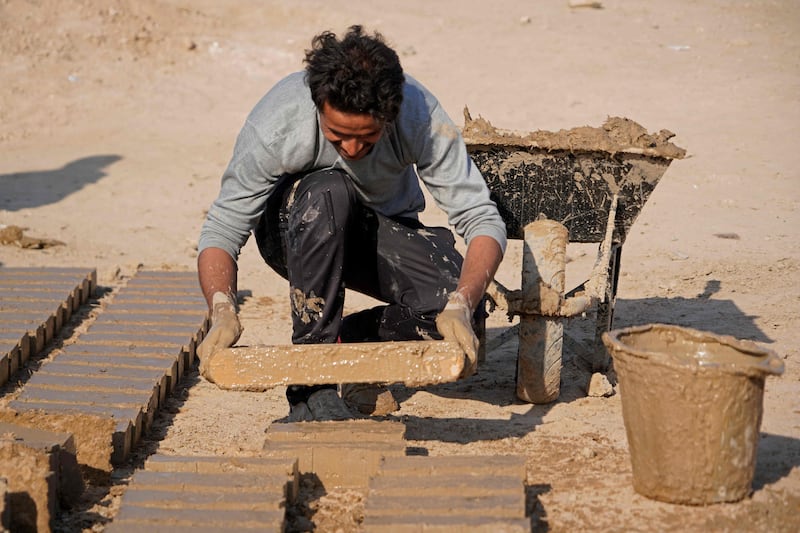 A worker makes traditional clay bricks.