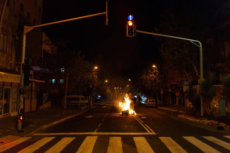A fire blazes in the middle of a street in Haifa's Hadar neighbourhood on Thursday night, as rioting continued in several Israeli cities. Daniel Rolider / Getty Images