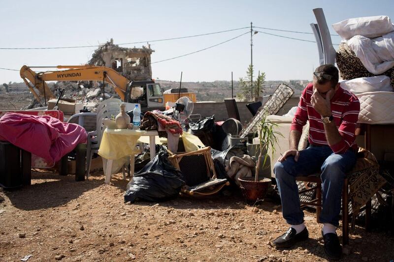 A Palestinian with his belongings after his home in East Jerusalem is demolished. Getty Images 
