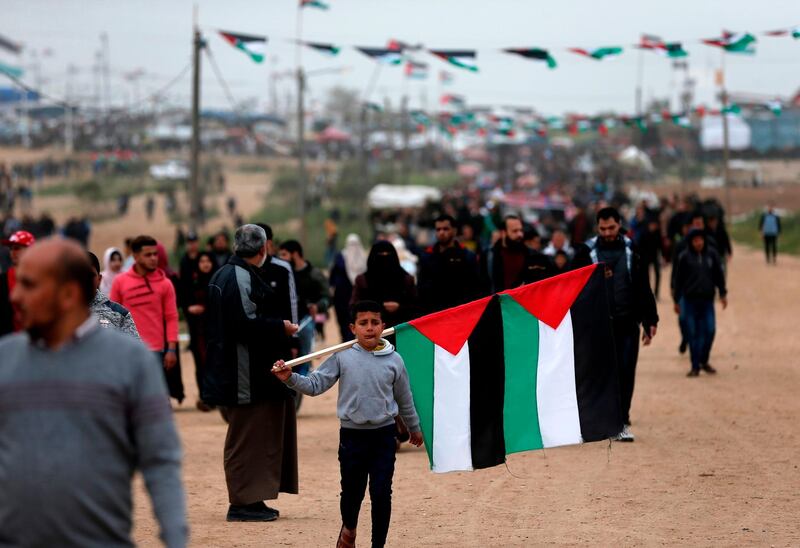 A boy carries national flags at a demonstration. AFP