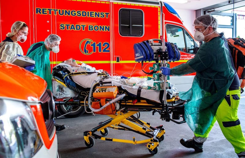 In this Handout photo made available by the University Hospital in Bonn (UKB) shows medical staff transporting one of two Italian patients who are infected with Covid-19 upon arrival at the University Hospital in Bonn, western Germany from Bergamo, Italy on March 28, 2020. AFP