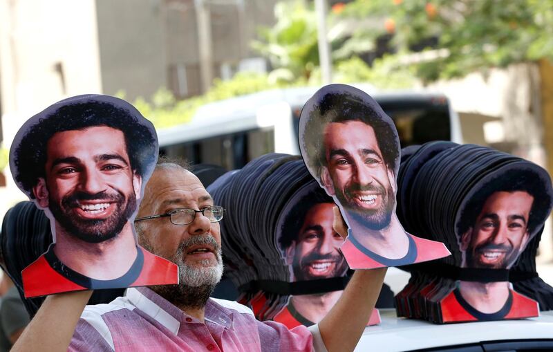 A Vender displays masks with pictures of Egyptian national soccer team player and Liverpool striker Mohammed Salah ahead of the opening match between Egypt and Zimbabwe of the African Cup of Nations in Cairo, Egypt, Friday, June 21, 2019.(AP Photo/Amr Nabil)