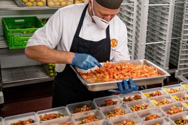 A member of Manchester United's catering staff helps prepare meals to deliver to 60,000 NHS workers across Greater Manchester. Courtesy Manchester United