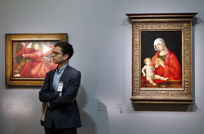 A man stands next to two paintings, one by Giovanni Bellini entitled ‘The Virgin and the Child’ (Italy, approx 1480-85), right, and another by Bernard Strigel entitled ‘The Angel and the Incense burner’ (Germany, 1520). Francois Guillot/AFP