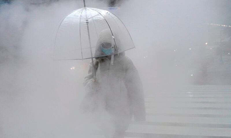 A person walks through steam coming from the street on Lexington Avenue in New York as the steam provides heat and cooling to many buildings in the city.  AFP