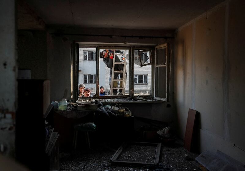 Workers look into a destroyed house after shelling near the city of Novoluhanske in Donetsk. Reuters