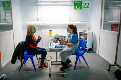 Immunisation Nurse Debbie Briody (R) fills in forms prior to administering the Pfizer/BioNtech Covid-19 vaccine to Staff Nurse Amanda Thompson at the NHS Louisa Jordan temporary hospital at the SEC Campus in Glasgow, Scotland on January 23, 2021.   / AFP / Andy Buchanan
