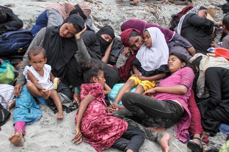 Rohingya women and children rest on the sand after making the sea crossing from Bangladesh to Aceh province, Indonesia. Reuters