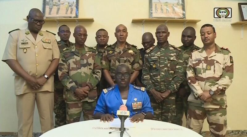 Nigerien military officer Maj Col Amadou Abdramane, centre, delivers a televised statement in which he said soldiers "decided to put an end to the regime" of President Mohamed Bazoum. AFP