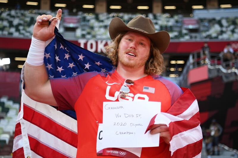 Ryan Crouser, of United States, holds a sign while celebrating winning the gold medal in the final of the men's shot put.
