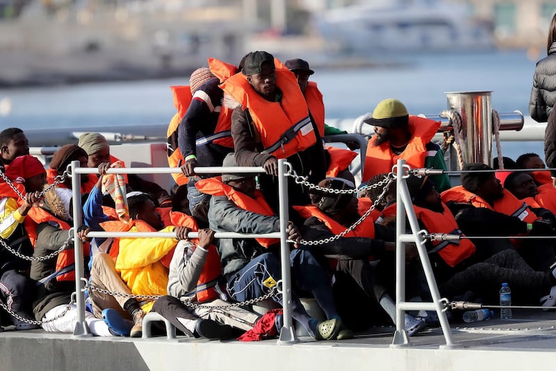 epa07504455 Migrants on board the Armed Forces of Malta vessel P51, rescued at sea within Malta's Search and Rescue Region from the German-flagged NGO rescue vessel Alan Kurdi, prepare to disembark at the Armed Forces of Malta maritime base at Hay Wharf, in Floriana, Malta, 13 April 2019. Malta has announced a deal to distribute among four EU nations the 64 migrants rescued at sea off Libya 10 days ago.  EPA/DOMENIC AQUILINA