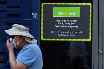 FILE PHOTO: A person wearing a protective face mask walks past a Job Centre Plus office, amidst the outbreak of the coronavirus disease (COVID-19) in London, Britain, August 11, 2020. REUTERS/Toby Melville/File Photo