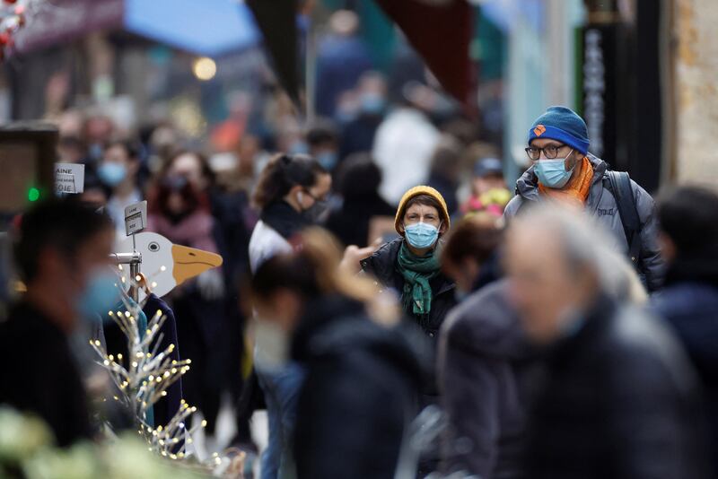 People, wearing protective face masks, walk on the Mouffetard street, amid the spread of the coronavirus disease (Covid-19) pandemic, in Paris, France, December 30, 2021. Reuters