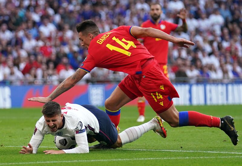 Mason Mount is bundled over by Andorra's Christian Garcia and earns England a penalty. PA