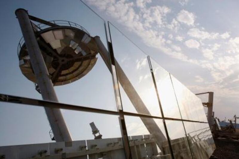 The "Beam Down" tower is reflected on solar panels in Masdar City, approximately 17 km (11 miles) from Abu Dhabi January 10, 2011, during a tour of the project by U.S. Secretary of State Hillary Clinton. REUTERS/Jumana El-Heloueh (UNITED ARAB EMIRATES - Tags: BUSINESS ENERGY ENVIRONMENT POLITICS) *** Local Caption ***  ABD08_EMIRATES-_0110_11.JPG