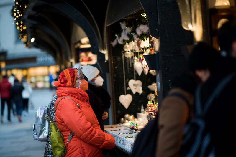 People wearing face masks visit a Christmas market in Vienna. AP