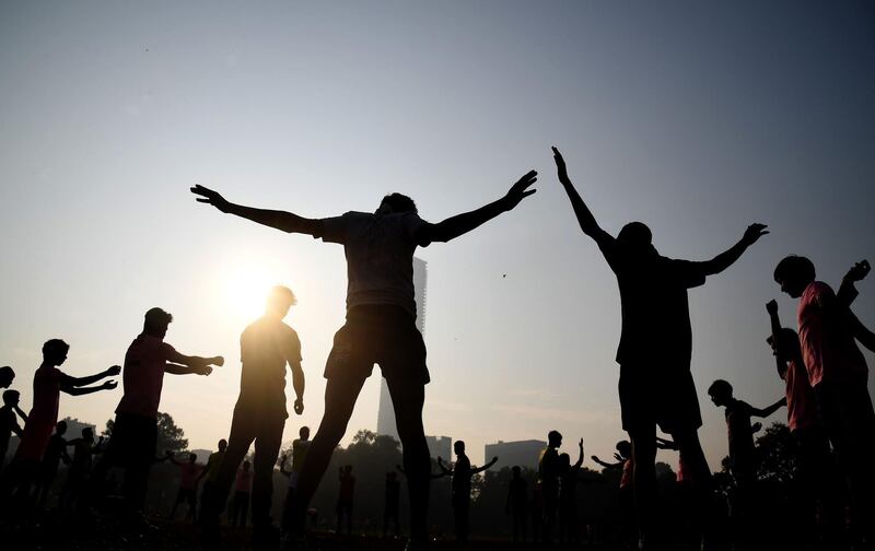 TOPSHOT - Indian players stretch before playing friendly rugby matches at the Maidan area in Kolkata on January 1, 2018. / AFP PHOTO / Dibyangshu SARKAR