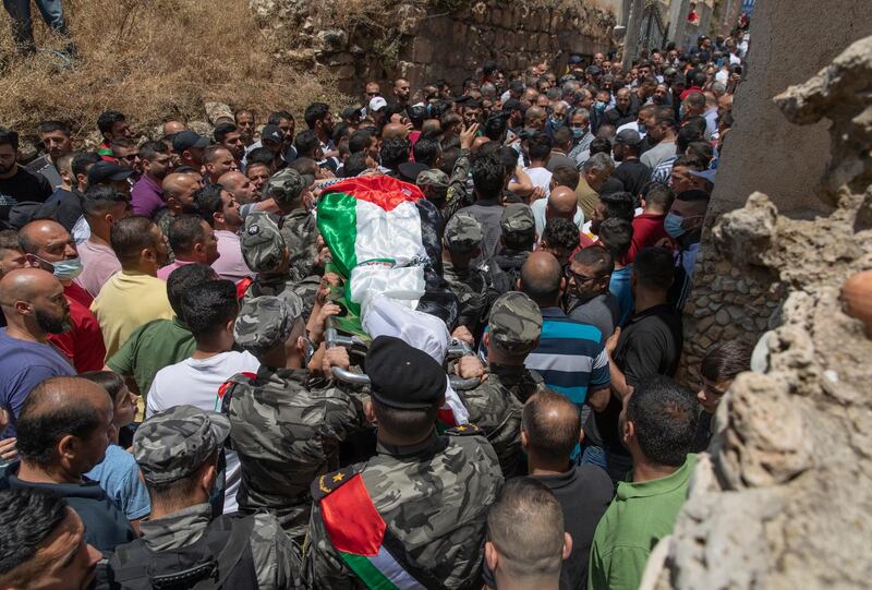 Palestinian security officer carry the body of Mohammad Daraghmeh out of the family house during his funeral in the West Bank village of Lubban, near Nablus, Wednesday, May 12, 2021. Israeli soldiers opened fire yesterday at a Palestinian vehicle at an army checkpoint north of the West Bank, killing Daraghmeh, a passenger, and critically wounding another, the Palestinian health ministry said. (AP Photo/Nasser Nasser)