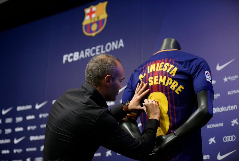 Andres Iniesta signs a shirt reading in Catalan: "Andres Iniesta forever". Manu Fernandez / AP Photo