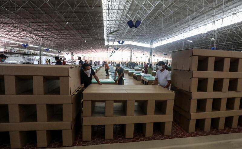 Indian volunteers set up beds made of cardboard as they prepare a Covid care facility which can accommodate around ten thousand Covid-19 patients at the Radha Soami Satsang Beas complex in New Delhi, India.  EPA