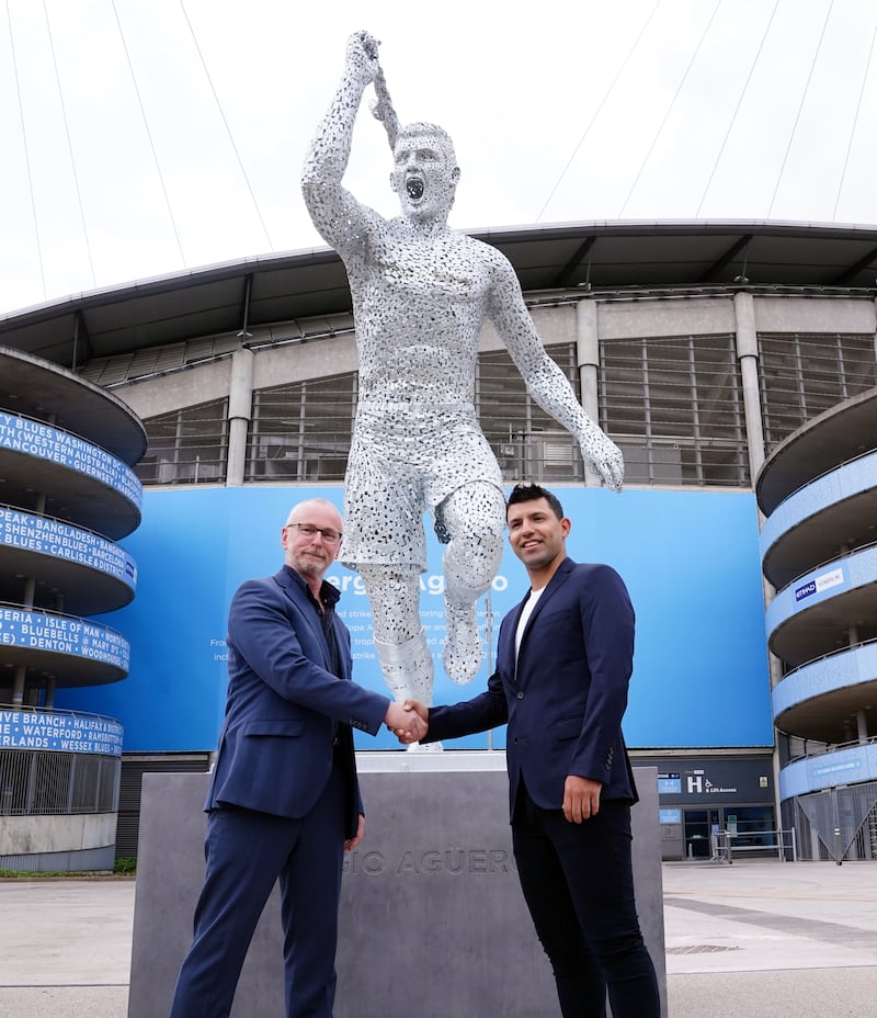 Manchester City legend Sergio Aguero, right, with sculptor Andy Scott during his statue unveiling outside the Etihad Stadium  to commemorate the 10th anniversary of the club's first Premier League title and the iconic "93:20" moment. AP