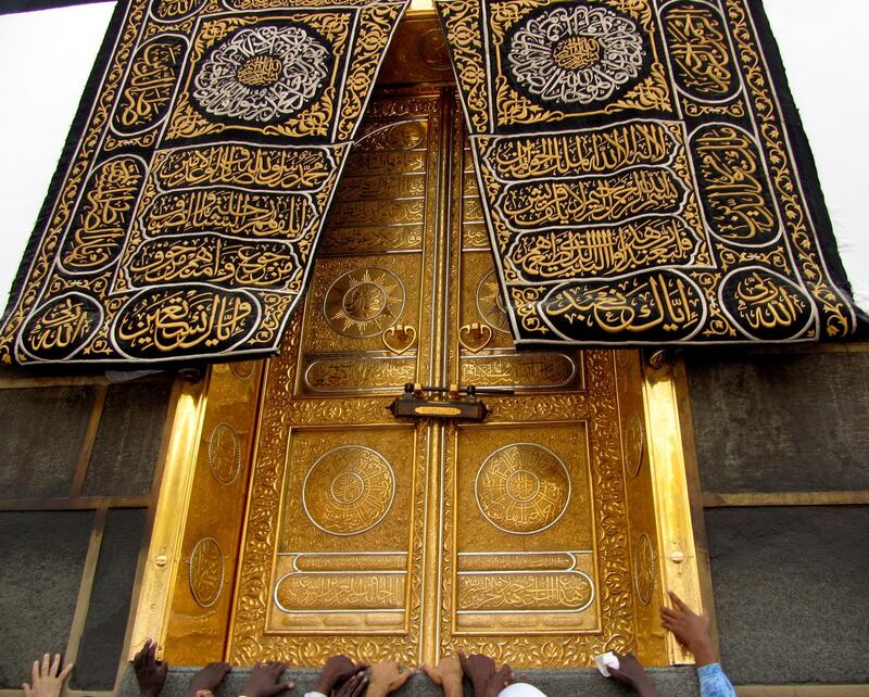 Muslim pilgrims touch the golden door of the Kaaba as they pray ahead of Hajj in Makkah, Saudi Arabia.  AP
